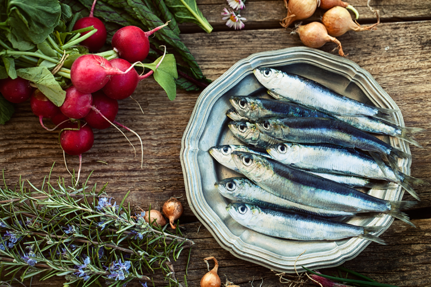 Fresh sardines. Fish with vegetables. Mediterranean fish on plate