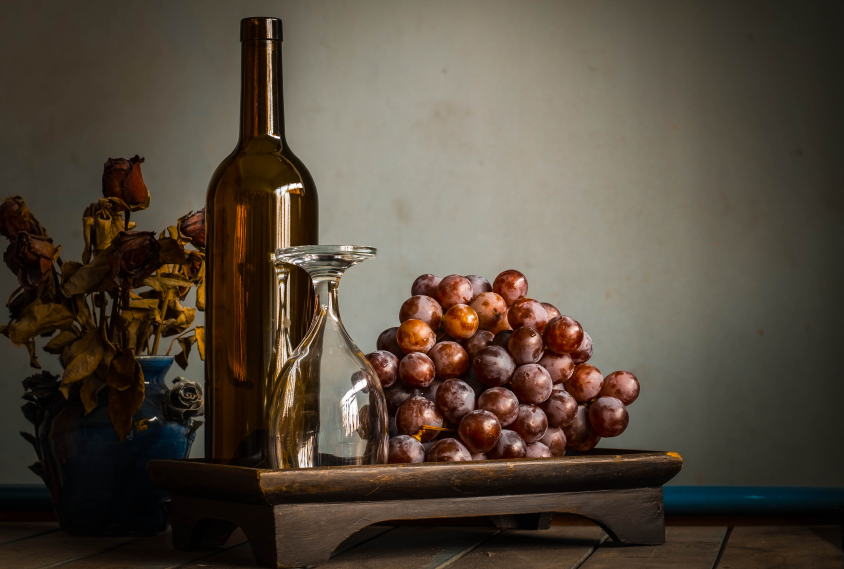 Empty glass and grapes on tray.