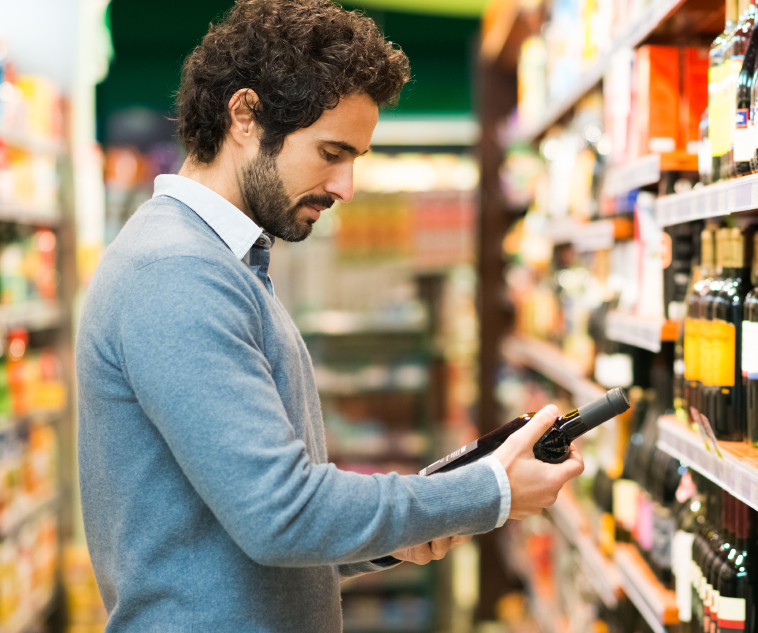 Man in a supermarket choosing a wine