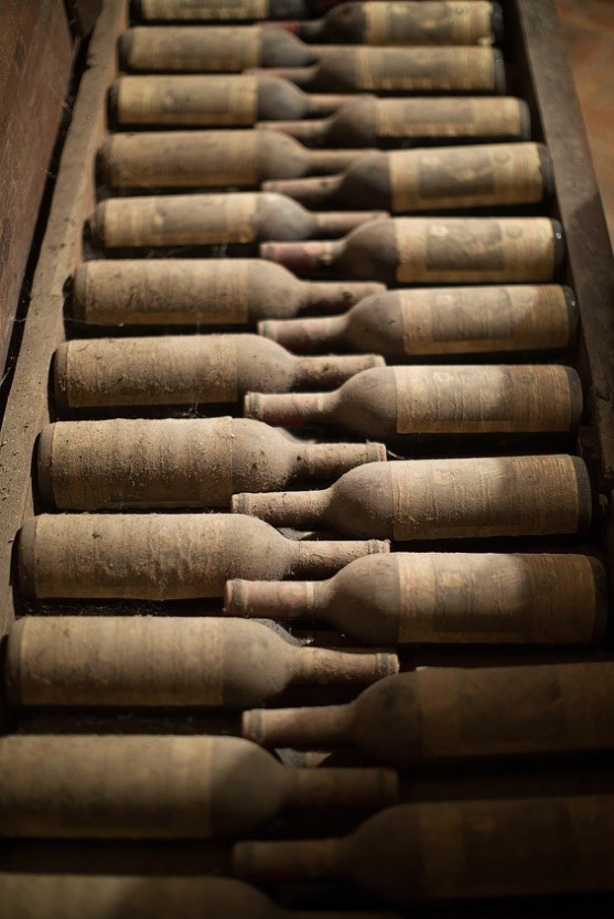 A collection of dusty vintage fine wine stored in a crate