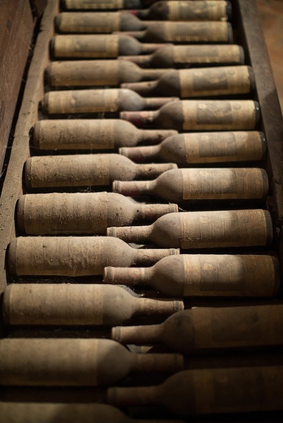 A collection of dusty vintage fine wine stored in a crate 