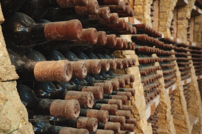 vintage bottles of wine gathering dust in a wine cellar stored in rows