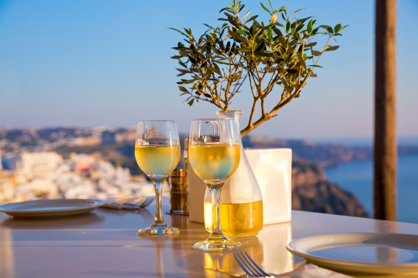 two glasses of white wine against a tropical backdrop on a restaurant table