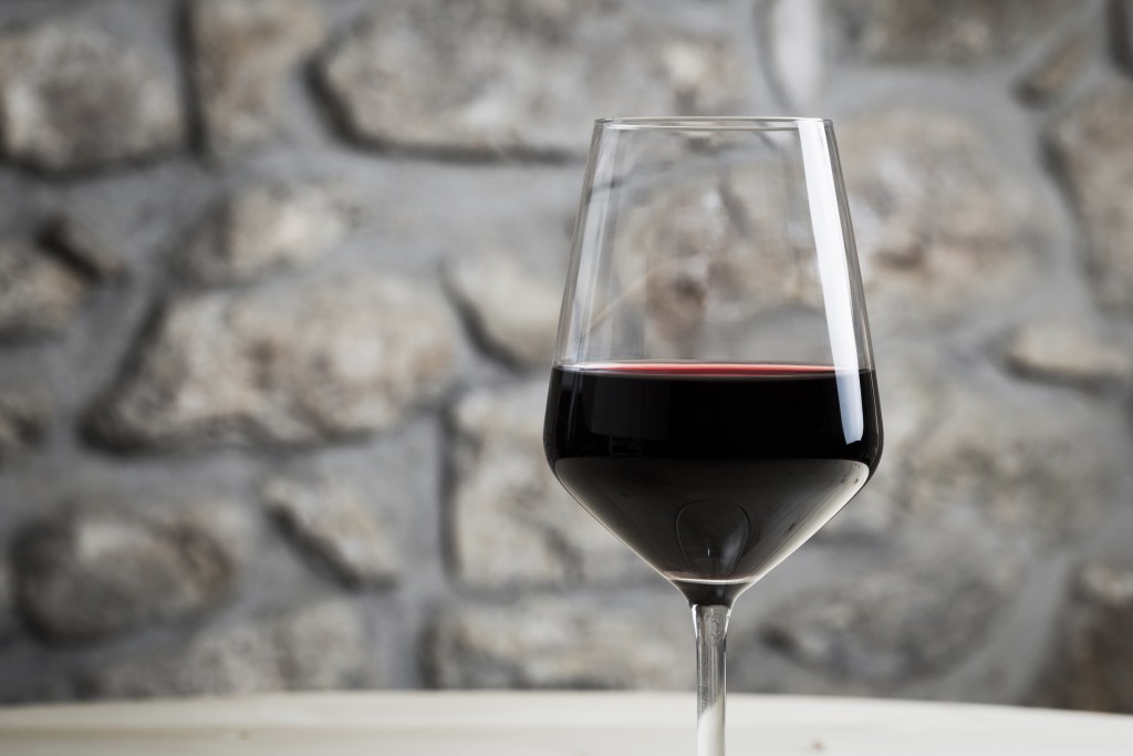 a single glass of red wine after being stored by a spiral cellar